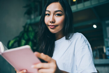 Positive woman with diary in cafe
