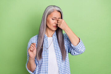 Photo of sad old grey hairdo lady hand head wear spectacles plaid shirt isolated on green color background