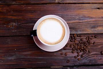Coffee cup and coffee beans on wooden background. Top view