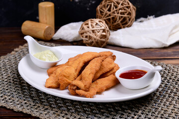 Homemade Sliced Wiener Chicken Schnitzel on plate on wooden table background. Healthy food.