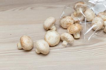 Raw fresh champignons on a white wooden table.