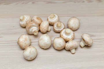 Raw fresh champignons on a white wooden table.