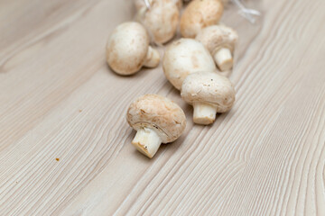 Fototapeta na wymiar Raw fresh champignons on a white wooden table.
