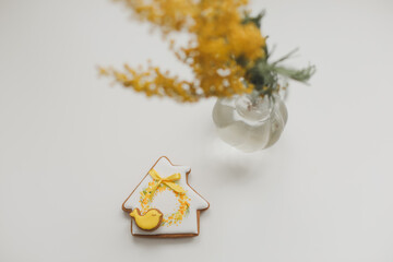 Easter gingerbread cookie and yellow mimosa florwers on white background