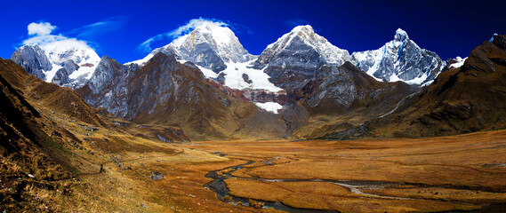 Panorama of snowy mountains and valley of rivers in the remote Cordillera Huayhuash Circuit near Caraz in Peru.