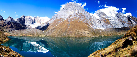 Panorama of snowy mountains and glacial lake valley in the remote Cordillera Huayhuash Circuit near Caraz in Peru.