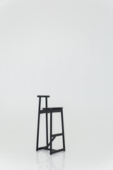 Naklejka premium black wooden bar stool in a white hall