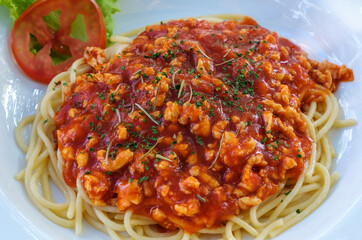 Closeup of the spaghetti red sauce with the minced pork in the withe plate.