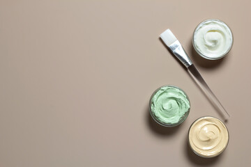 Beauty cosmetic products. Homemade beauty facial clay mask and brush on pastel beige background with copy space.
