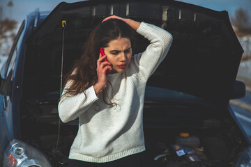 Broken down car troubles. Confused and upset young beautiful woman trying to call for help or a tow...