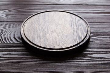 Round cutting board with groove on wooden table