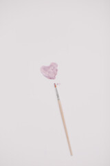 Heart symbol made of watercolor and paintbrush on white background. Valentine's Day, Woman Day composition