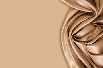 Photography of beautiful elegant wavy beige / light brown satin silk luxury cloth fabric texture with monochrome background design. Copy space. Card or banner