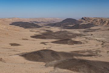 View of Ramon Crater from West to East as seen from Mount Ramon, a 500 m deep, the world's largest erosion cirque, located in the Negev Desert, south of Beer Sheba, Israel. - obrazy, fototapety, plakaty