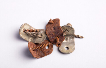 metal angle brackets with corrosive rust and damaged screws, white background