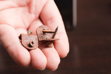 angle brackets with corrosive rust in a man's hand,