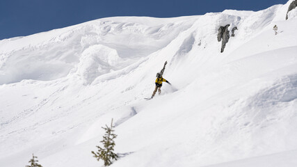 Fototapeta na wymiar Freerider snowboarder running down the picturesque alpine landscape. Fresh powder snow, blue sky on background. 