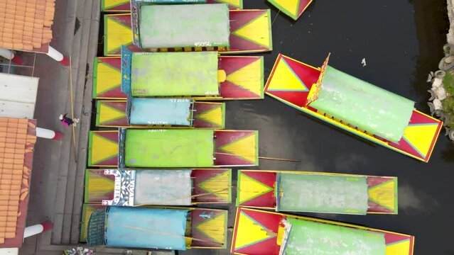 Top view of colorful boats in Xochimilco, Mexico Drone flying over  Channel Colorful Trajineras or Gondolas on the Canals