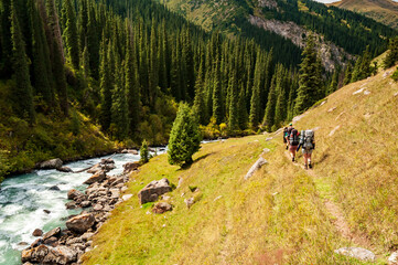 Trekking group of hikers in Karakol valley on trail to Ala Kul lake. Karakol valley, Issyk-kul...