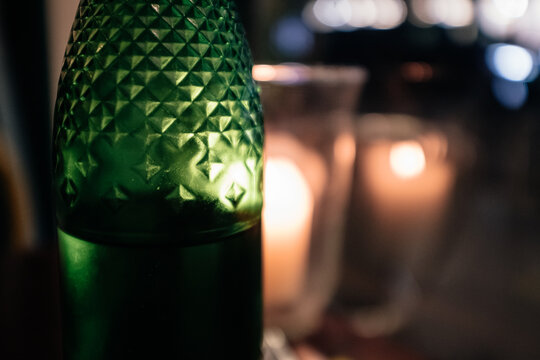 Green beer bottle backlit on a dark scene