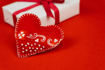 Valentines Day concept with copy space. Red textile heart and goft box on red papper background