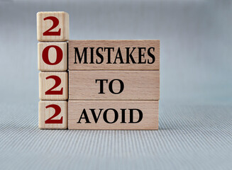 MISTAKES TO AVOID 2022 - words on wooden blocks on gray background