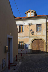 Ancient european town street view with small blush house with wooden gates on sunny day, old slovenian city of Piran