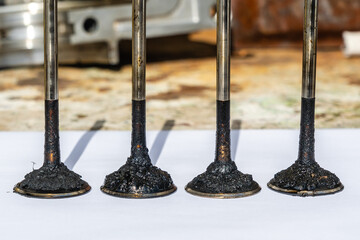 Engine valves in oil covered with soot. Heat-resistant steel. Automotive, repair servicing.
