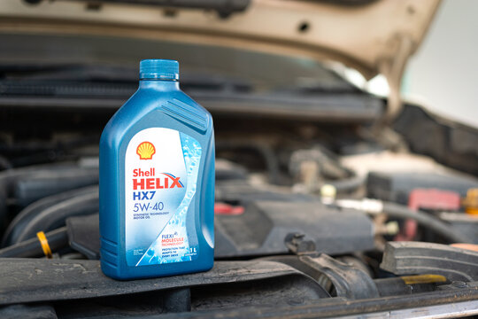 Thailand - Feb 2022 : Shell Helix HX7 a synthetic engine motor oil which is placed on car hood, preparing for engine oil replacement. Vehicle service editorial photo.