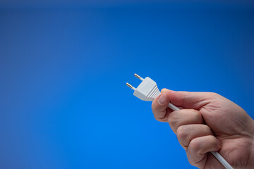 European style electric socket and cord held in hand by male hand. Close up studio style, isolated...