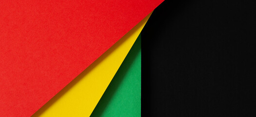 Black History Month color background. African American history month celebration. Abstract red, yellow, green color flag on black paper background - obrazy, fototapety, plakaty