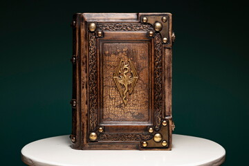 old brown leather book with golden dragon symbol and cracked map