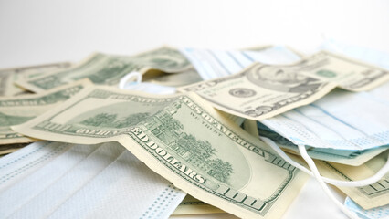 Background from money. Scattered dollars and medical mask