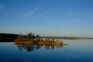 small island and trees reflecting in Lake Jordan NC on a bright clear winter day