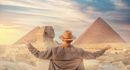 Travel man in hat background pyramid of Egyptian Giza and Sphinx, sunset Cairo, Egypt