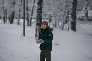 Fototapeta na wymiar a boy walks in a snow park