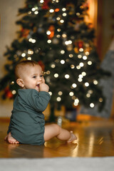 the kid plays with a large wooden airplane on the background of a Christmas tree