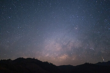 Fototapeta na wymiar The Milky Way rising in the sky with meteor above the silhouette mountains at Mae Hong Son province Northern Thailand.