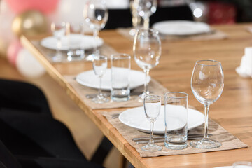 Glass dishes on a wooden table. clean and empty. cozy atmosphere. serving a banquet