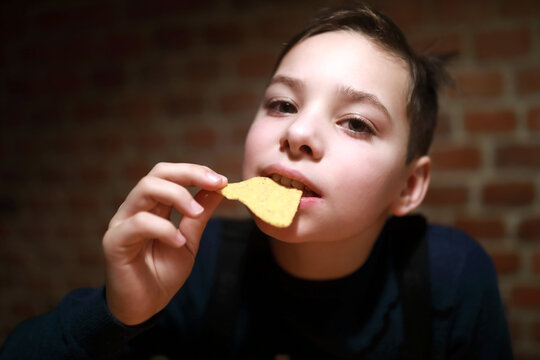 Child Eating Nachos In Restaurant