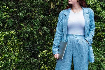 Businesswoman with blue suit holding a laptop. Copy space for text