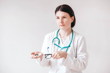 Woman doctor with pills in her hands on a white background. Taking vitamins or medications. Copy, empty space for text