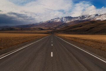 Fototapeta premium An empty asphalt road stretching into the distance through the Altai Mountains.