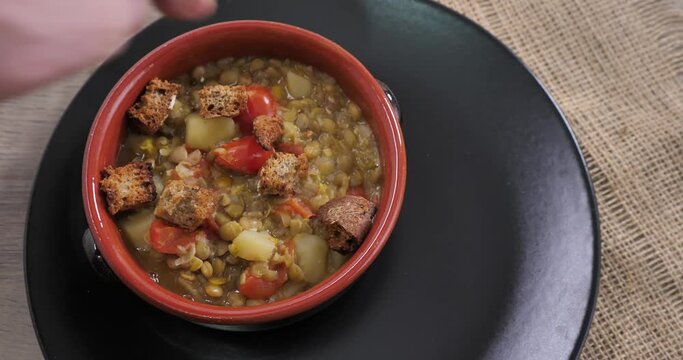 Il cuoco mette i crostini nella zuppa