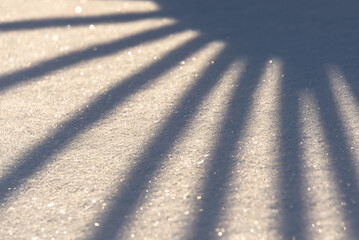 Shadows in the form of rays of the sun on the snow.