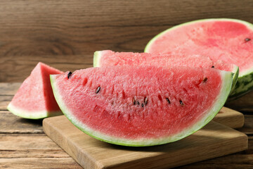 Slices of tasty ripe watermelon on wooden table