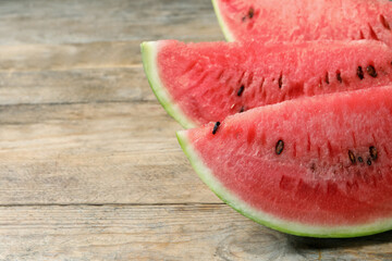 Slices of tasty ripe watermelon on wooden table, closeup. Space for text
