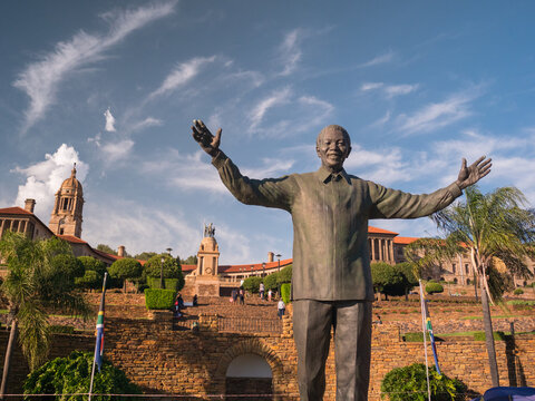 Pretoria, South Africa - circa 2019: Statue of Nelson Mandela with Union Buildings background arms wide open welcoming visitors