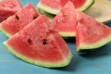 Slices of tasty ripe watermelon on turquoise wooden table, closeup
