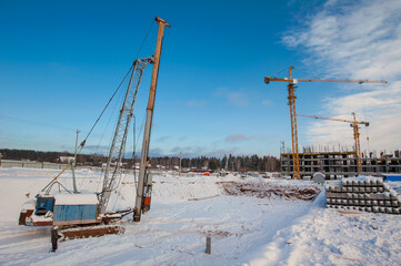 clogged piles in the foreground of a new house under construction in winter